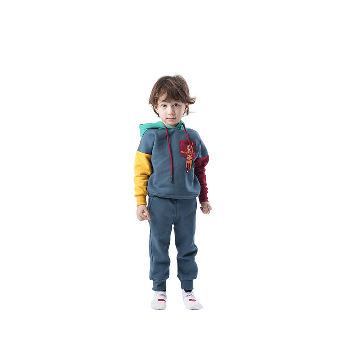 Child wearing a colorful hoodie and blue tracksuit on a white background