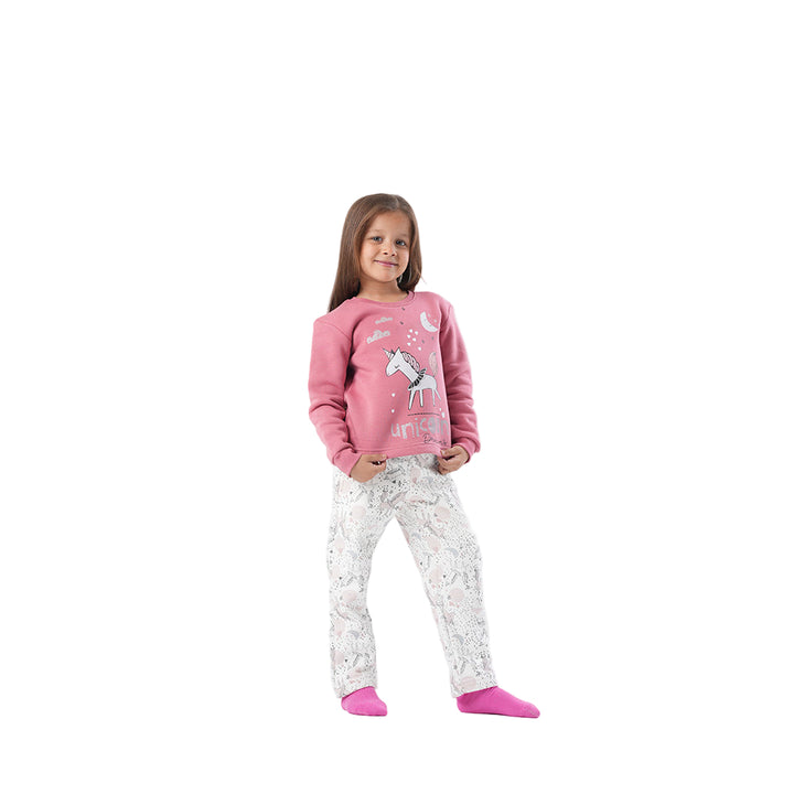 Young girl wearing a pink sweater with unicorn design and white pants with pink socks 