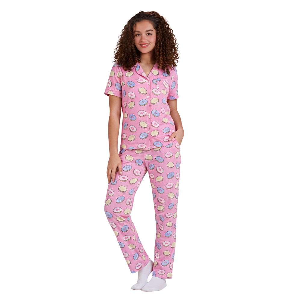 Woman wearing a pink pajama set with colorful patterns on a white background