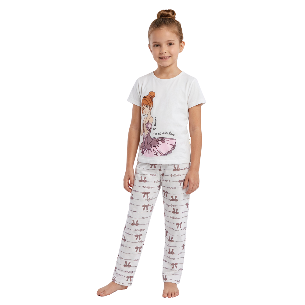 Young girl wearing a white t-shirt with a graphic design and patterned pants on a white background