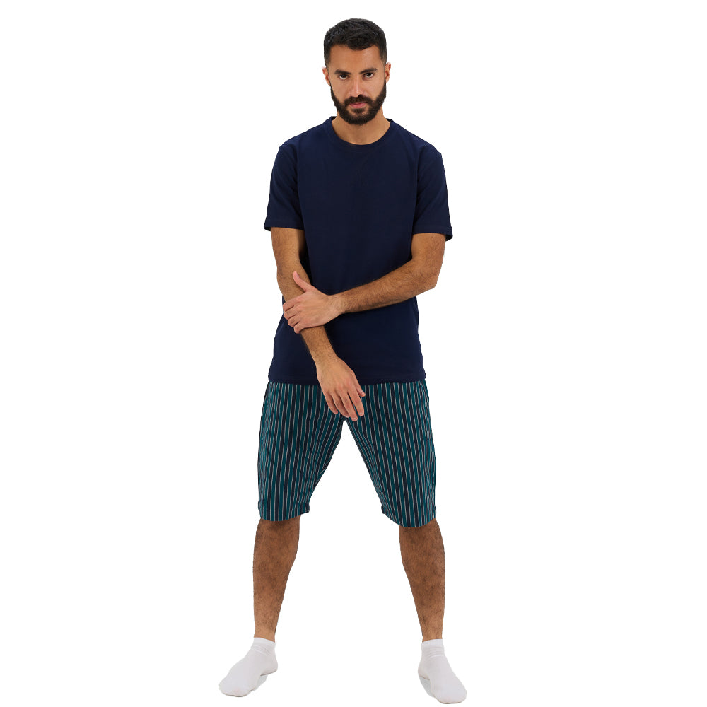 Man wearing a navy t-shirt and striped shorts on a white background